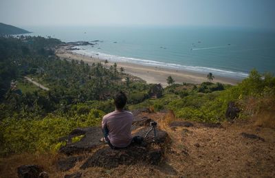 Rear view of man sitting on beach