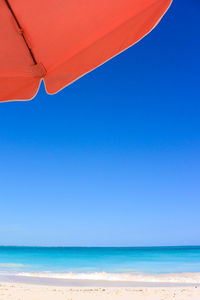 Scenic view of beach against clear blue sky