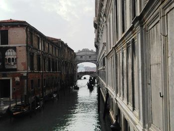 Bridge of sighs over canal amidst buildings