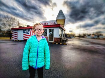 Portrait of smiling girl standing against sky