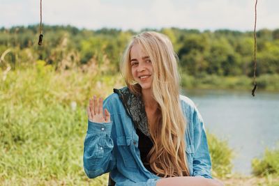 Portrait of young woman sitting on field