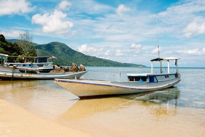 Boats moored on sea against sky