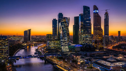 Illuminated cityscape against sky at night