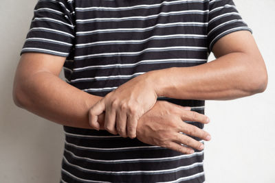 Midsection of woman standing against white background