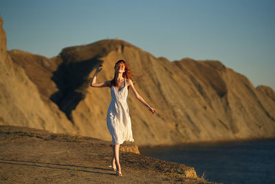 Woman standing on mountain against clear sky