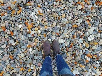 Low section of person standing on pebbles