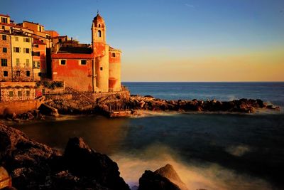 Scenic view of sea by buildings against sky