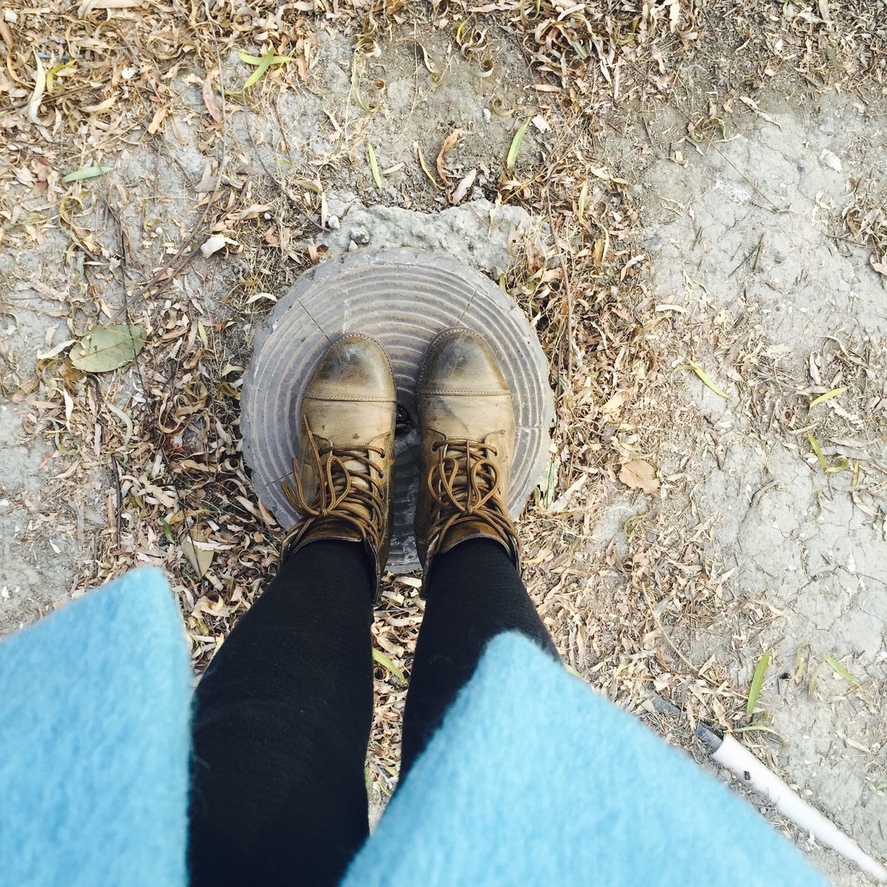 high angle view, low section, shoe, personal perspective, person, cobblestone, day, outdoors, street, directly above, footpath, one person, paving stone, sunlight, road, concrete, textured, footwear, elevated view, standing