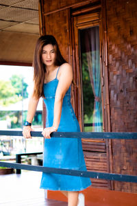 Beautiful young woman standing against wall