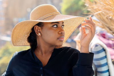 Portrait of beautiful african american model girl in stylish sun hat. fashion black woman on natural 