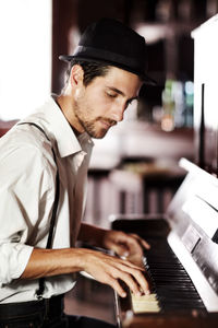 Side view of man playing piano