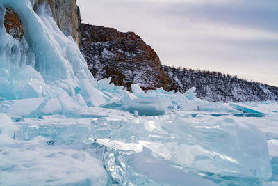 Ice on land against mountains during winter