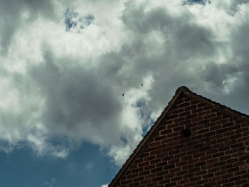 Low angle view of building against cloudy sky