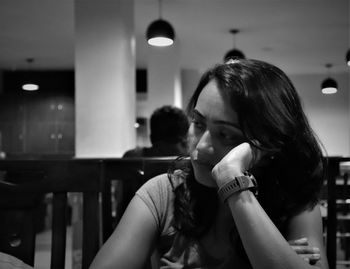 Monochrome portrait of woman absorbed in her thoughts in a restaurant