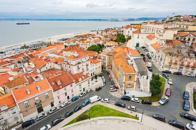 High angle view of townscape by sea against sky