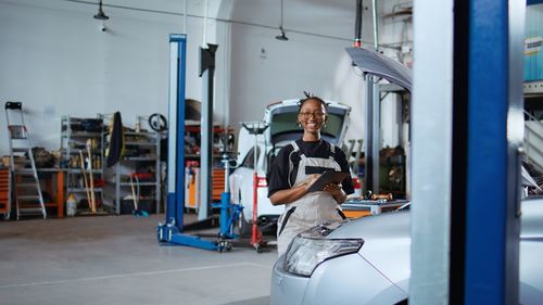 Rear view of woman standing in car