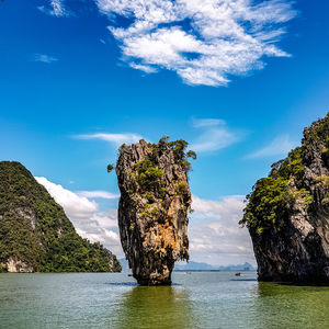 Rock formation by sea against blue sky