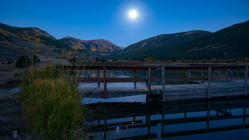 Scenic view of lake against mountains at night