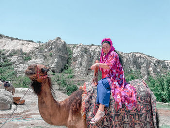 Rear view of woman standing on a camel