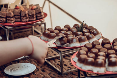 Midsection of person holding ice cream in plate on table