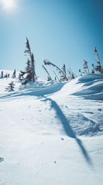 Snow covered land against clear blue sky