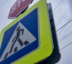 Low angle view of road sign against blue sky