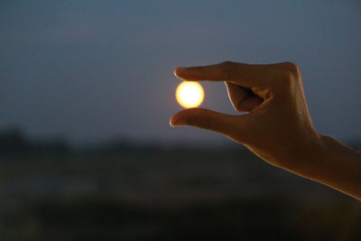 Person holding sun during sunset