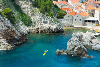 High angle view of rocks on adriatic sea against houses