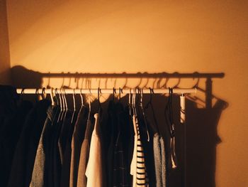 Close-up of clothes hanging in rack against wall