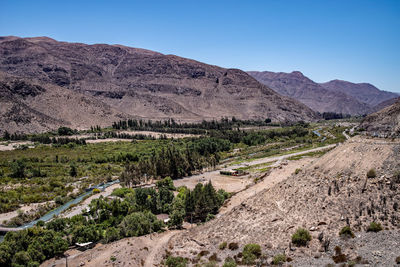 Scenic view of landscape and mountains against clear blue sky