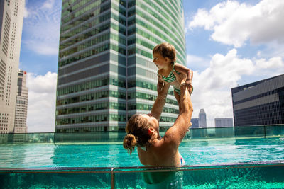 Full length of shirtless man in swimming pool against sky