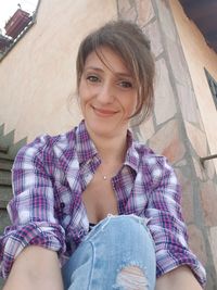 Portrait of smiling young woman sitting outdoors