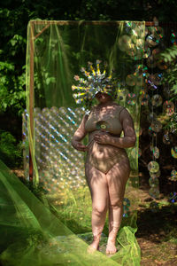 Portrait a woman in a reflective mask in a beige bikini against the background of a cd / dvd case