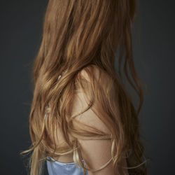 Rear view of woman with hair against black background