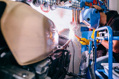 Mature mechanic repairing motorcycle in garage