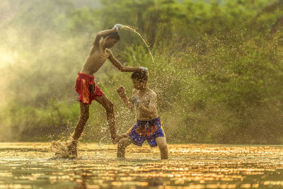 Boys fighting while standing on field