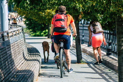 Rear view of people walking on footpath