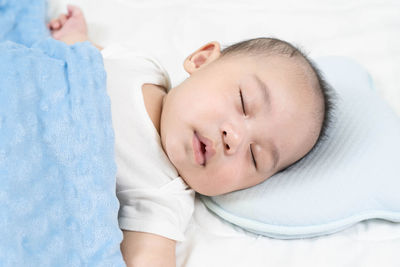 Close-up of baby sleeping on bed