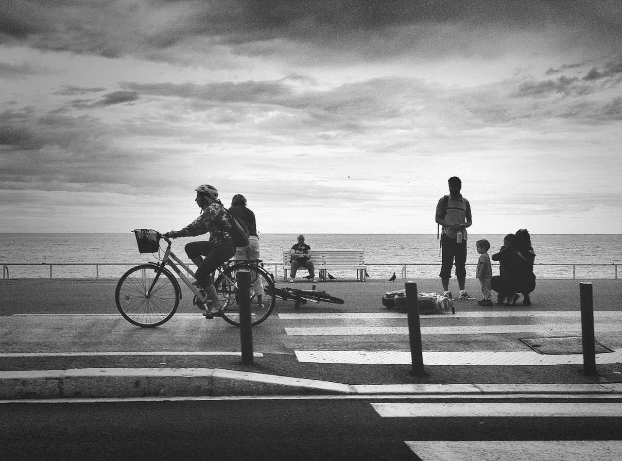 sea, sky, horizon over water, bicycle, water, men, lifestyles, cloud - sky, leisure activity, railing, transportation, beach, person, silhouette, full length, togetherness, land vehicle, cloud