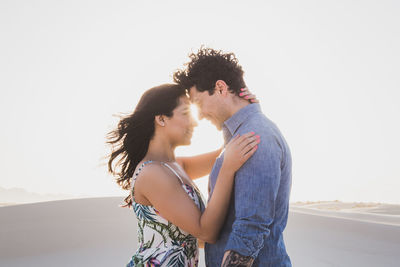 Side view of young couple standing outdoors