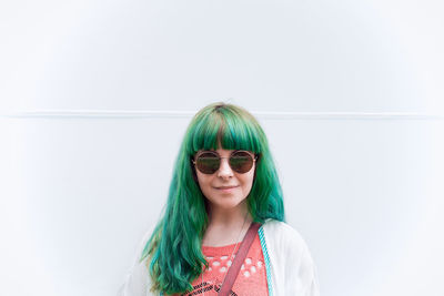 Portrait of smiling young woman against white background