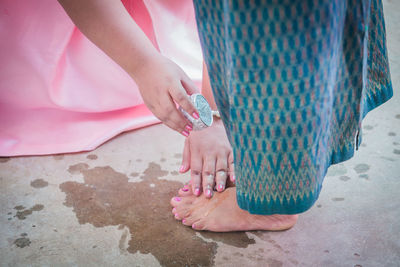 Bride pouring water on legs of mother during wedding