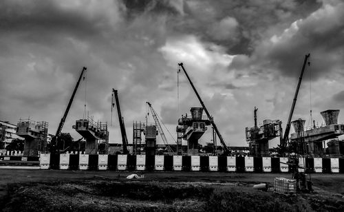 Cranes at construction site against sky in city