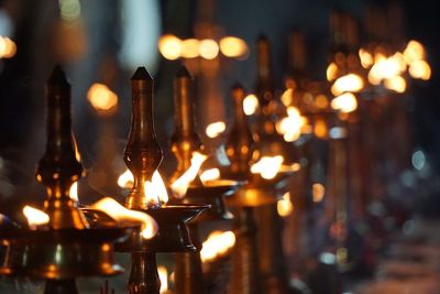 Close-up of illuminated candles on table at night