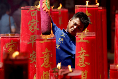 Young man holding cross in temple
