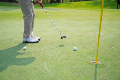 Low section of person playing with ball on grass