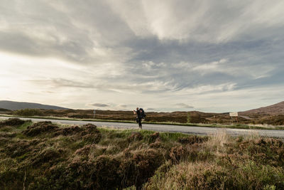 A young man is taking a photo of the sunset from a road near sligachan, september 2019
