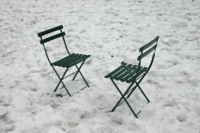 High angle view of empty chairs on snow