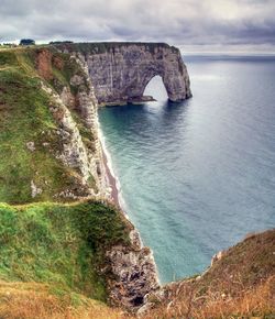 Rock formations by sea against sky