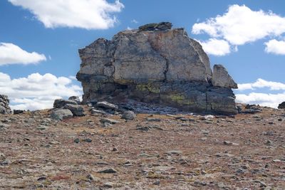 Rock formations on field against sky